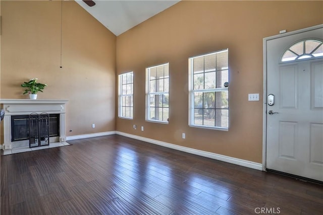 foyer with baseboards, a fireplace with flush hearth, and wood finished floors