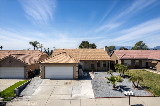 single story home featuring stucco siding, driveway, a tile roof, and an attached garage