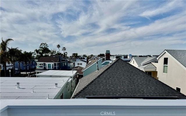 exterior space with a residential view, stucco siding, and roof with shingles