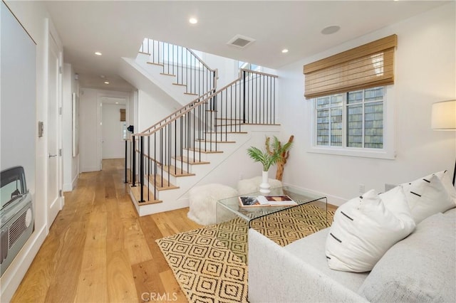 living room with visible vents, stairway, recessed lighting, wood finished floors, and heating unit