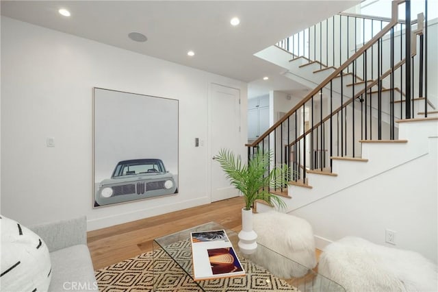 living room with recessed lighting, stairway, baseboards, and wood finished floors