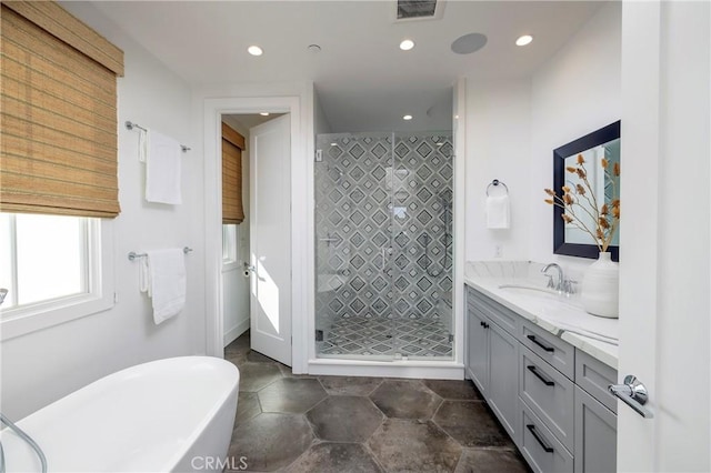 full bath featuring visible vents, a shower stall, a freestanding bath, recessed lighting, and vanity