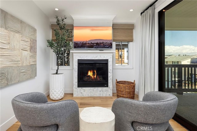 sitting room with recessed lighting, wood finished floors, baseboards, and a high end fireplace