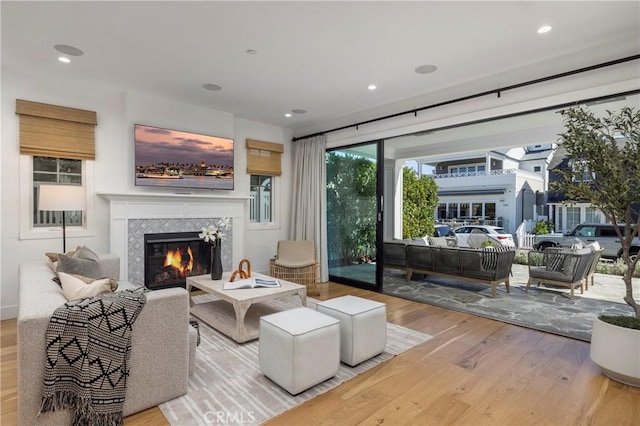 living area featuring recessed lighting, wood finished floors, and a fireplace