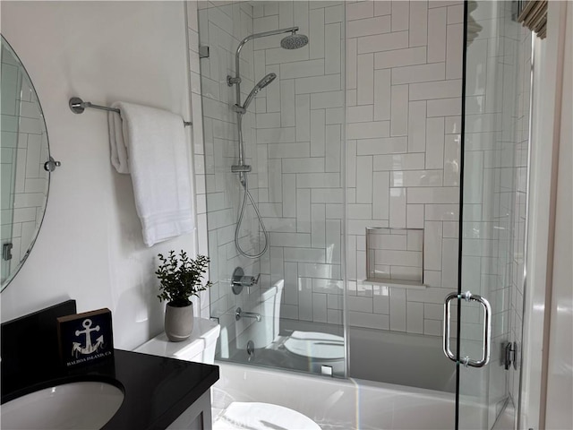 full bath featuring bath / shower combo with glass door, vanity, and toilet