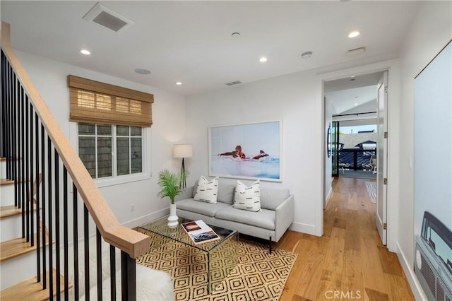 living room with visible vents, recessed lighting, stairs, and wood finished floors