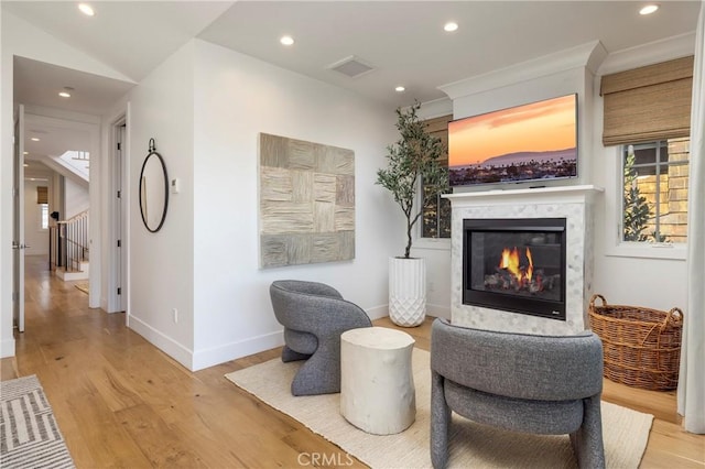 living area featuring visible vents, wood finished floors, a high end fireplace, recessed lighting, and baseboards