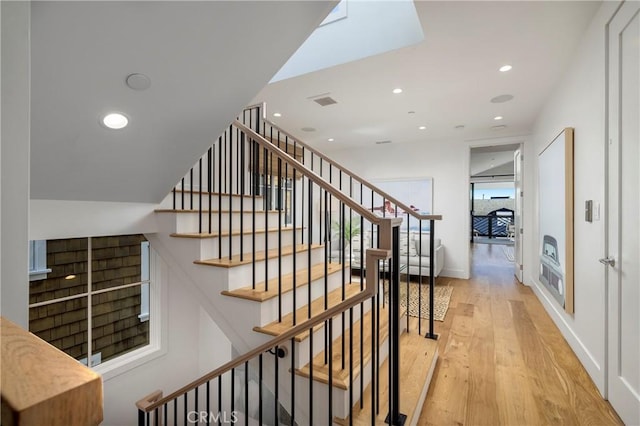 stairway featuring visible vents, recessed lighting, wood finished floors, and baseboards