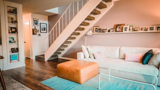 living area featuring stairway, built in shelves, and wood finished floors