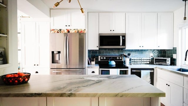 kitchen featuring stainless steel appliances, backsplash, and white cabinets