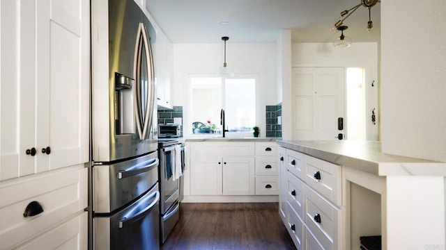 kitchen featuring white cabinets, stainless steel appliances, dark wood-type flooring, and a sink