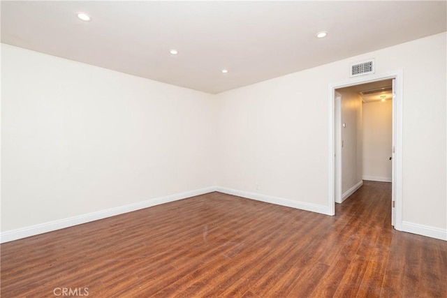 empty room featuring visible vents, recessed lighting, baseboards, and wood finished floors