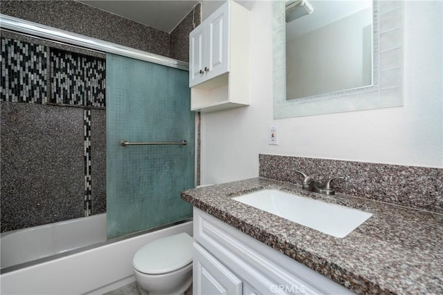 full bathroom featuring combined bath / shower with glass door, toilet, and vanity