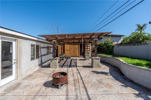 view of patio featuring a fire pit, a pergola, and fence