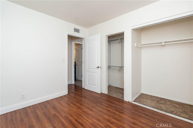 unfurnished bedroom featuring visible vents, baseboards, and wood finished floors