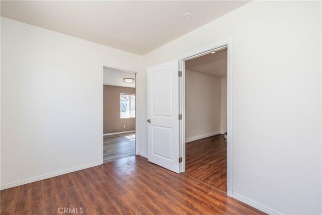 spare room featuring wood finished floors and baseboards