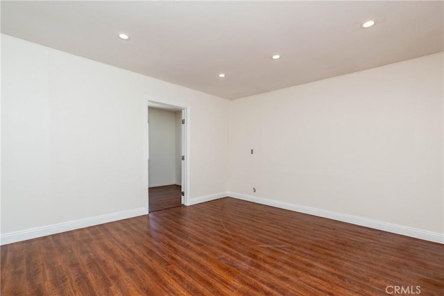 empty room featuring recessed lighting, baseboards, and wood finished floors