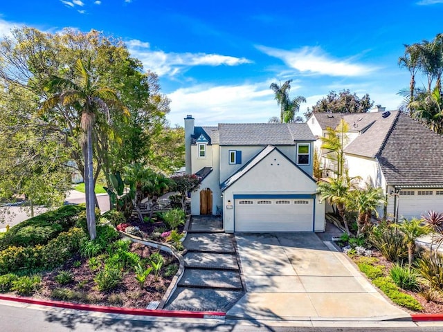 traditional-style house with a garage, driveway, and stucco siding