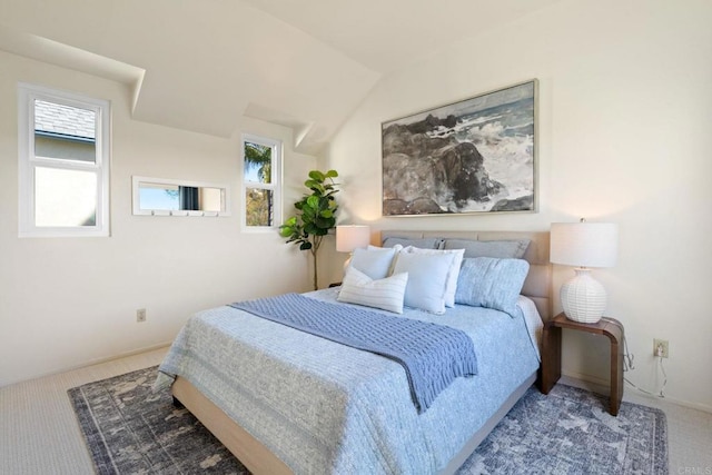 bedroom with vaulted ceiling, multiple windows, and carpet flooring