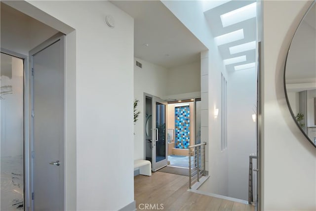 hallway featuring visible vents and light wood-style floors