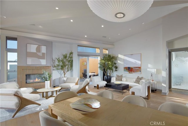 dining room with a glass covered fireplace, recessed lighting, light wood-type flooring, and a wealth of natural light