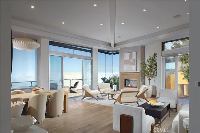 living room with a glass covered fireplace, recessed lighting, visible vents, and wood finished floors