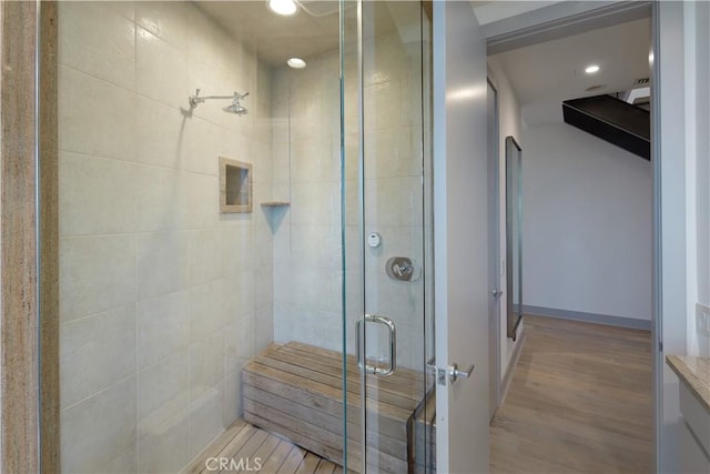 full bath with recessed lighting, a shower stall, and wood finished floors