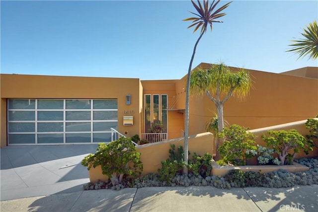 pueblo-style home with stucco siding and a fenced front yard