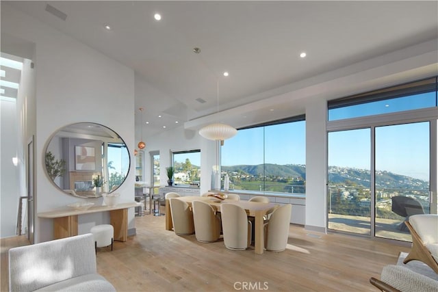 dining space with recessed lighting, light wood-type flooring, and a mountain view