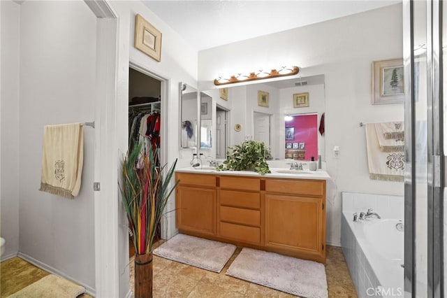 bathroom featuring a bath, a sink, a walk in closet, and double vanity