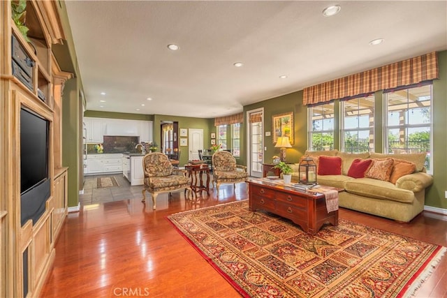 living area with baseboards, recessed lighting, and wood finished floors
