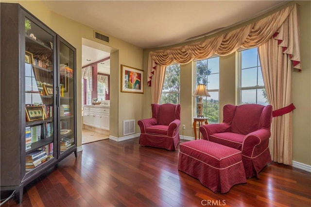 living area featuring visible vents, hardwood / wood-style flooring, and baseboards