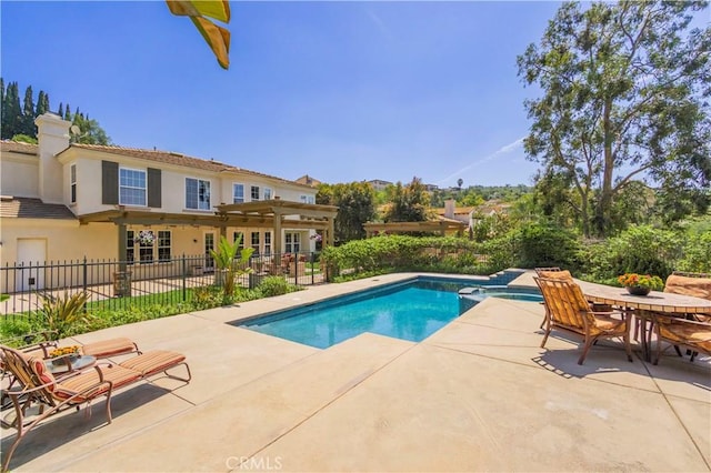 view of swimming pool featuring a patio, a pool with connected hot tub, and fence