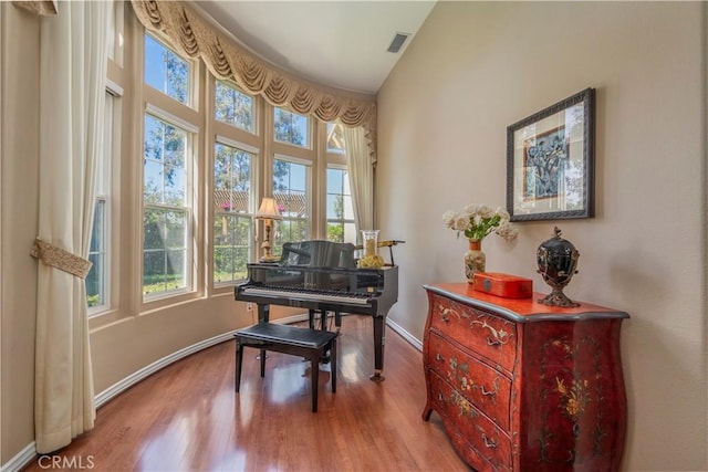 sitting room with wood finished floors, baseboards, visible vents, and a wealth of natural light
