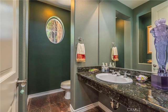 bathroom with baseboards, a sink, and toilet