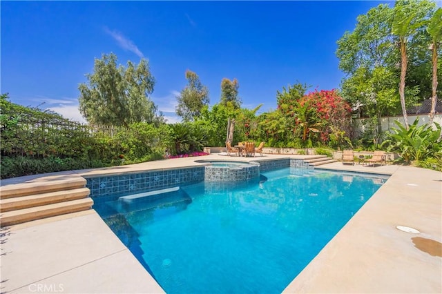 view of pool with a patio, a fenced backyard, and a pool with connected hot tub