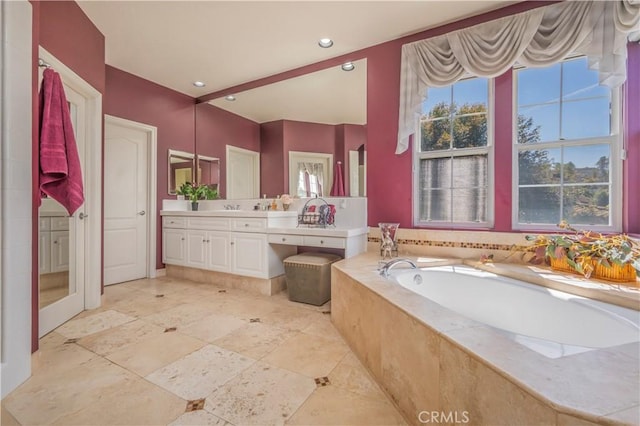 bathroom featuring recessed lighting, vanity, and a garden tub