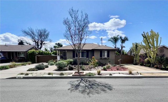 ranch-style home featuring concrete driveway, a gate, and stucco siding