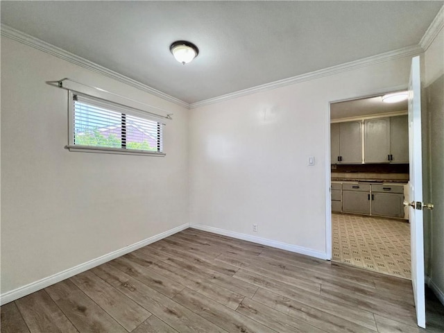 unfurnished room featuring baseboards, wood finished floors, and ornamental molding