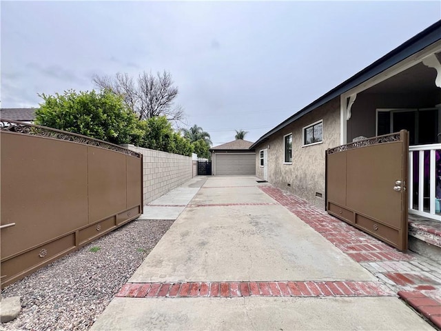 view of patio / terrace with a garage, an outdoor structure, and fence