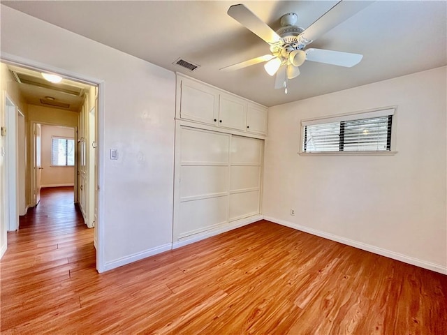 unfurnished bedroom with a closet, visible vents, baseboards, and light wood-style floors