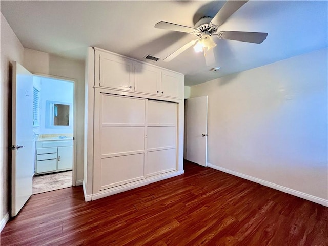 unfurnished bedroom with visible vents, ceiling fan, baseboards, dark wood finished floors, and a closet