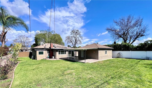 rear view of property featuring stucco siding, a lawn, and a fenced backyard