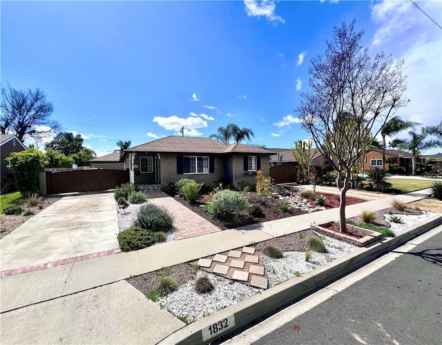 single story home featuring stucco siding, fence, driveway, and a gate