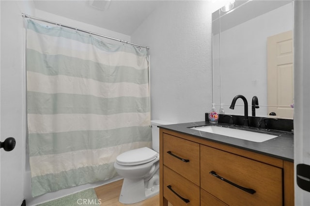 bathroom with toilet, wood finished floors, and vanity