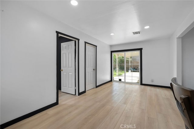 interior space featuring visible vents, light wood-type flooring, and baseboards