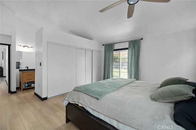 bedroom featuring a closet, light wood-type flooring, ceiling fan, and vaulted ceiling