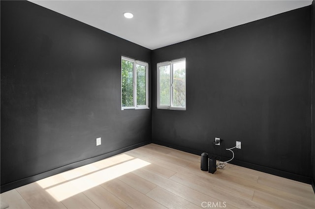 empty room featuring recessed lighting, baseboards, and wood finished floors