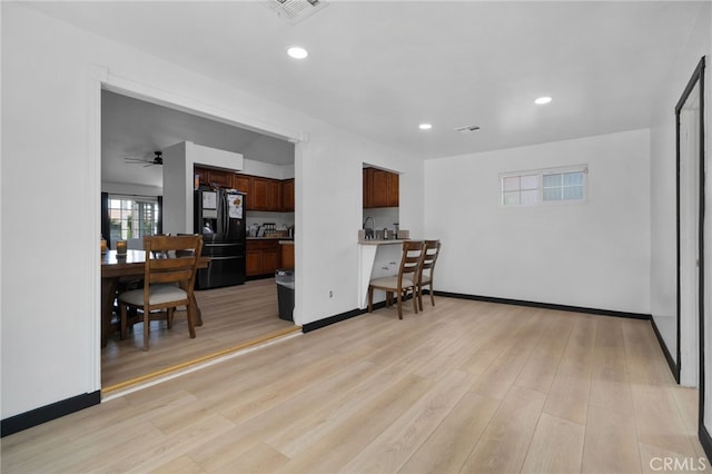 kitchen with light wood finished floors, visible vents, baseboards, recessed lighting, and black refrigerator with ice dispenser