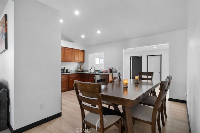 dining room with lofted ceiling, recessed lighting, baseboards, and light wood finished floors